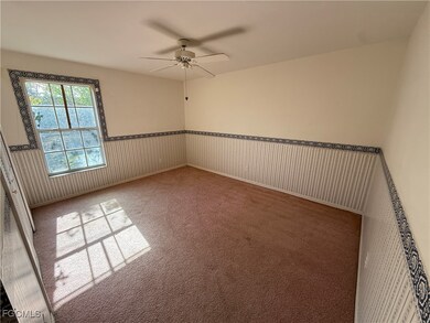 Spare room featuring a ceiling fan and carpet
