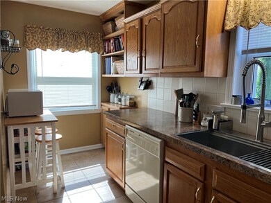 Kitchen with dishwasher and a wealth of natural light, tasteful backsplash, and light tile floors
