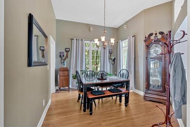 Dining space with a chandelier, baseboards, and light wood-type flooring