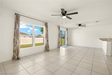 Unfurnished room with ceiling fan, light tile patt