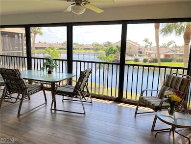 Sunroom featuring a water view, a residential view, and wood finished floors