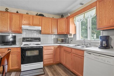 Kitchen with brown cabinets, light countertops, wh
