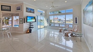 Living room with ornamental molding, ceiling fan,