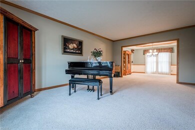 Formal living room with crown molding is open to t