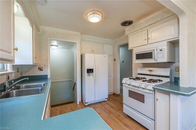 Kitchen with white cabinetry and wood look laminate flooring