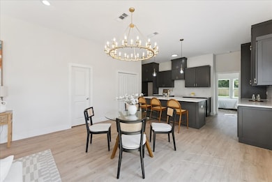 Dining area featuring light wood-type flooring, a chandelier, and recessed lighting