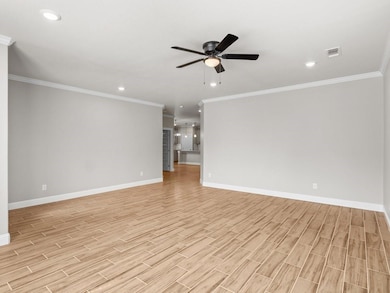 Unfurnished living room featuring ceiling fan, lig