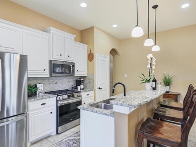 Kitchen featuring a center island with sink, light