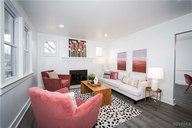 Living room with a fireplace and dark wood-type fl