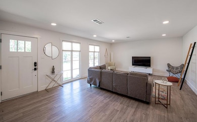Living area with wood finished floors, recessed l