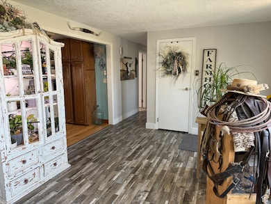 Interior space with a textured ceiling and dark wood-type flooring