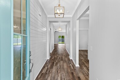 Hallway with ornamental molding, wooden walls, and