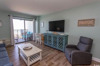 Living room featuring a wall mounted AC, wood finished floors, and baseboards