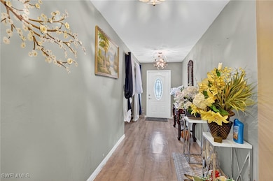 Doorway with hardwood / wood-style flooring and a chandelier