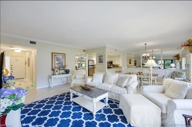 Living area featuring a chandelier, tile patterned floors, crown molding, and baseboards