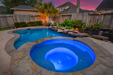 Pool features a custom rock waterfall. This is an AMAZING backyard.