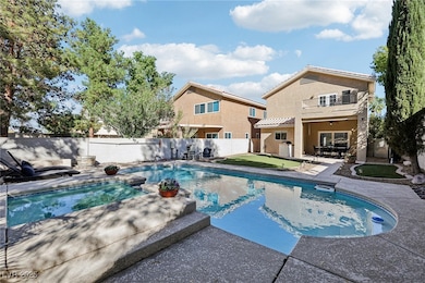 View of pool with a patio, an in-ground hot tub, a balcony, and a fenced backyard