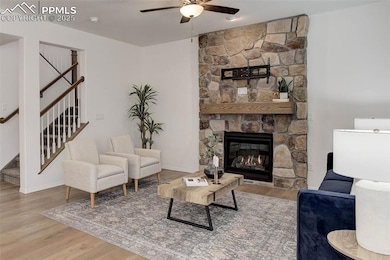 Living area featuring a ceiling fan, stairs, wood 