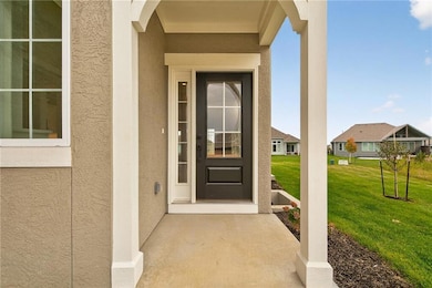 Property entrance with stucco siding and a lawn