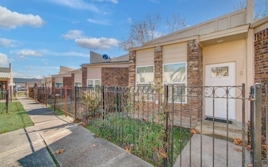 Features a view of the neighboring townhomes properties surrounding facing the pool. The townhome has a modern design with windows, providing plenty of natural light.