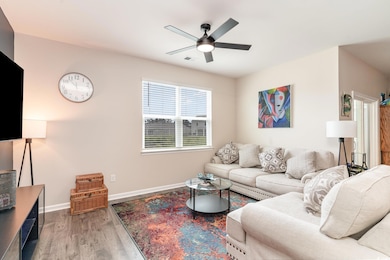 Living area featuring visible vents, ceiling fan, 
