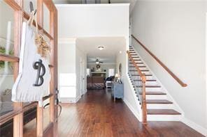 Foyer featuring a ceiling fan, baseboards, wood fi