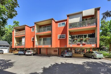 View of apartment building / complex featuring covered parking