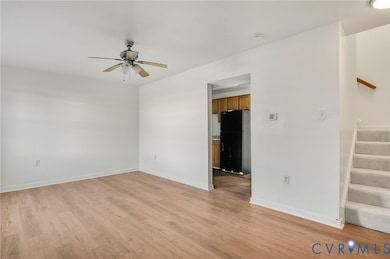 Unfurnished room featuring light wood-style flooring, stairs, and ceiling fan