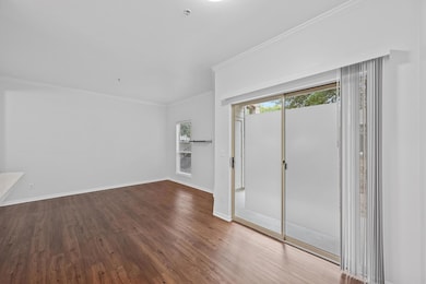 Empty room with crown molding, baseboards, and wo