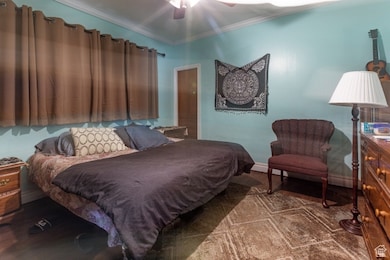 Bedroom featuring ornamental molding, wood finished floors, and ceiling fan