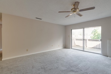Carpeted spare room with baseboards, a textured ce