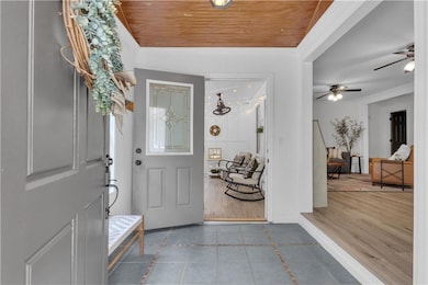 MF Tiled entryway with inlaid floor details, ornamental molding, and a ceiling fan