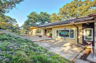 Back of property with a patio area, brick siding, and a chimney
