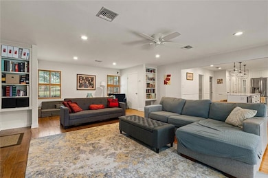 Living room featuring wood-type flooring, recessed lighting, and ceiling fan