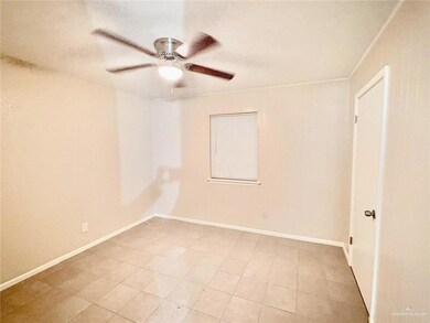 Unfurnished room featuring a ceiling fan, light tile patterned floors, and crown molding