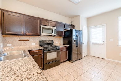 Kitchen featuring backsplash, dark brown cabinets