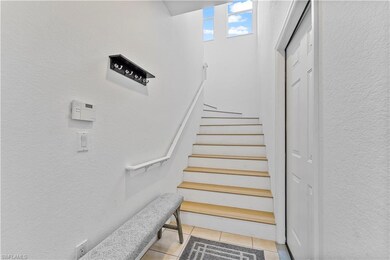 Stairs featuring a textured wall and tile patterned floors