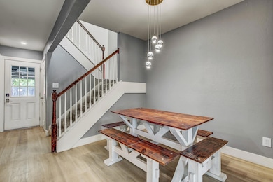 Dining space featuring wood finished floors, stai