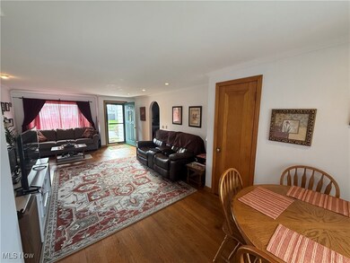 Living room featuring wood finished floors, arched walkways, crown molding, and recessed lighting
