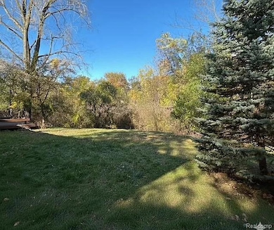 View of grassy yard featuring a forest view