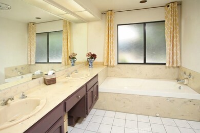 Private en suite master bathroom with His and Her dual basin vanity, large dressing mirror, relaxing soaking tub, glass enclosed shower, privacy window and tiled floors.