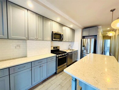 Kitchen featuring appliances with stainless steel finishes, gray cabinets, light stone countertops, backsplash, and recessed lighting