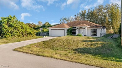 View of front of property with a front yard, driveway, stucco siding, and an attached garage