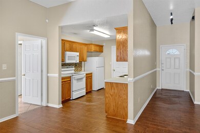 Kitchen featuring white appliances, light counter