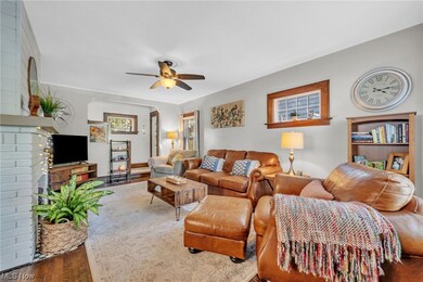 Living room featuring ceiling fan, a brick fireplace, and hardwood / wood-style flooring