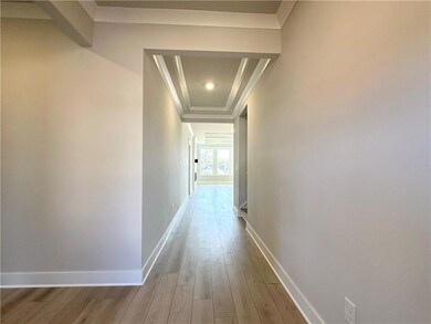 Hall with light wood-style flooring and crown molding