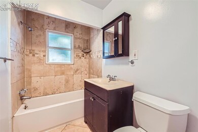 Full bathroom featuring toilet, vanity, tile patte