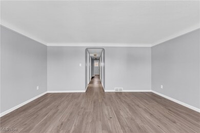 Spare room with wood finished floors, baseboards, and visible vents