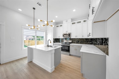 This kitchen features sleek white cabinetry, a str