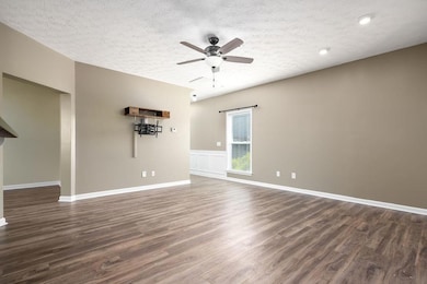 Spare room featuring ceiling fan, dark wood finish